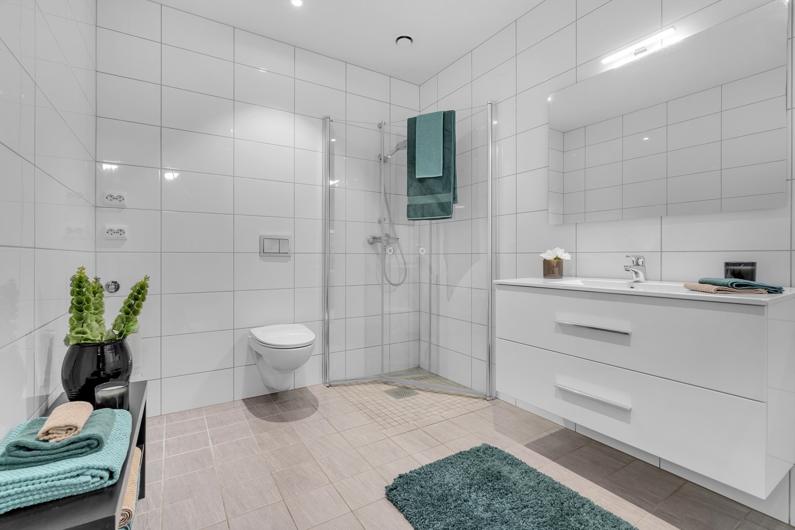 Baderomsinnredningen er funksjonell og elegant, og inkluderer dusjdører i glass. Det finnes opplegg for vaskemaskin, og det vegghengte toalettet bidrar til et rent og ryddig utseende. Galleribilde