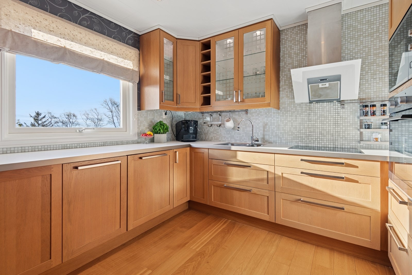 Det er lagt keramiske fliser på vegg over benkeplaten og kjøkkenet er utstyrt med integrerte hvitevarer. Galleribilde