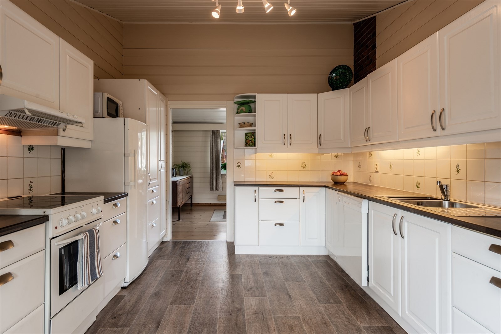 Kjøkken: Innredning med profilerte fronter. Benkeplater i laminat. Det er kjøkkenventilator med avtrekk ut. Galleribilde