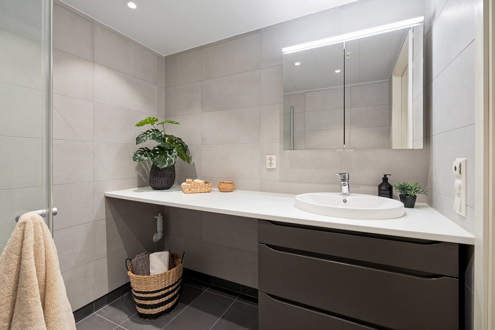 Her finner du vegghengt toalett, dusjnisje med glassdør, speil med lys, samt opplegg for vaskemaskin. Galleribilde