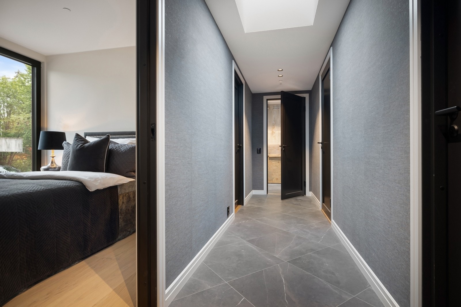 Gangen i soveromms avdelingen er innbydende med tapetserte vegger og flislagt gang. Det ligger vannbåren varme i alle gulv i leiligheten.