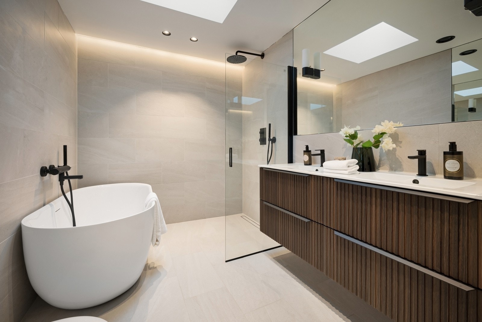 Lekker baderomsinnredning med innredning fra Oslo VVS i mørk utførsel. Frittstående badekar, tapwell blandebatterier og takdusj med håndspyler.