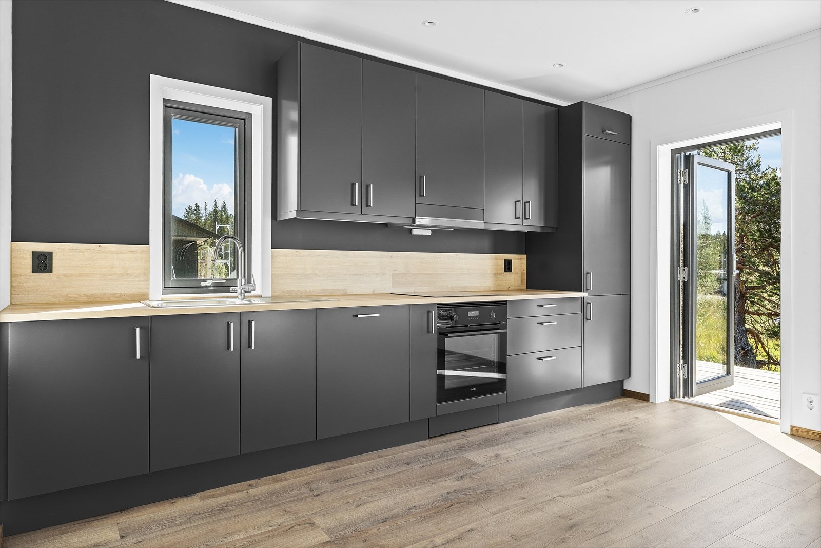 Innbydende kjøkken med mørke, slette fronter og laminert benkeplate Galleribilde