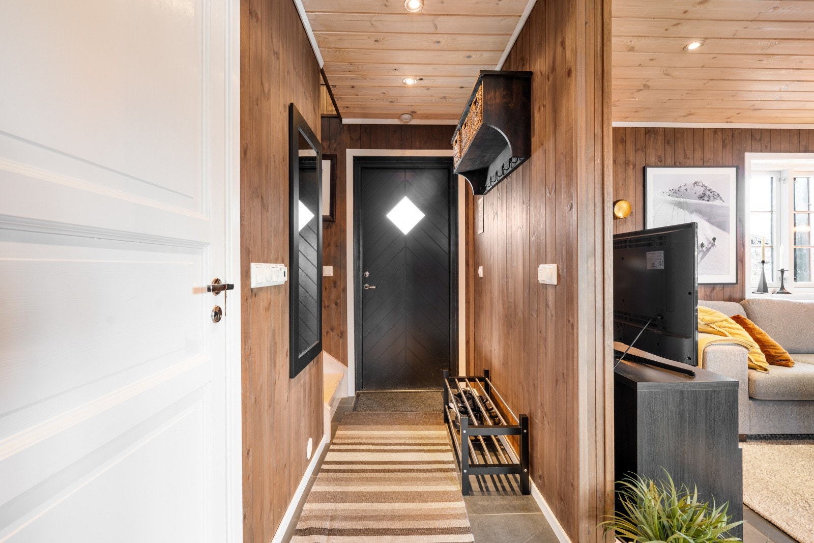 Flislagt gang/entrè med plass til å henge av seg ytterklær. Galleribilde