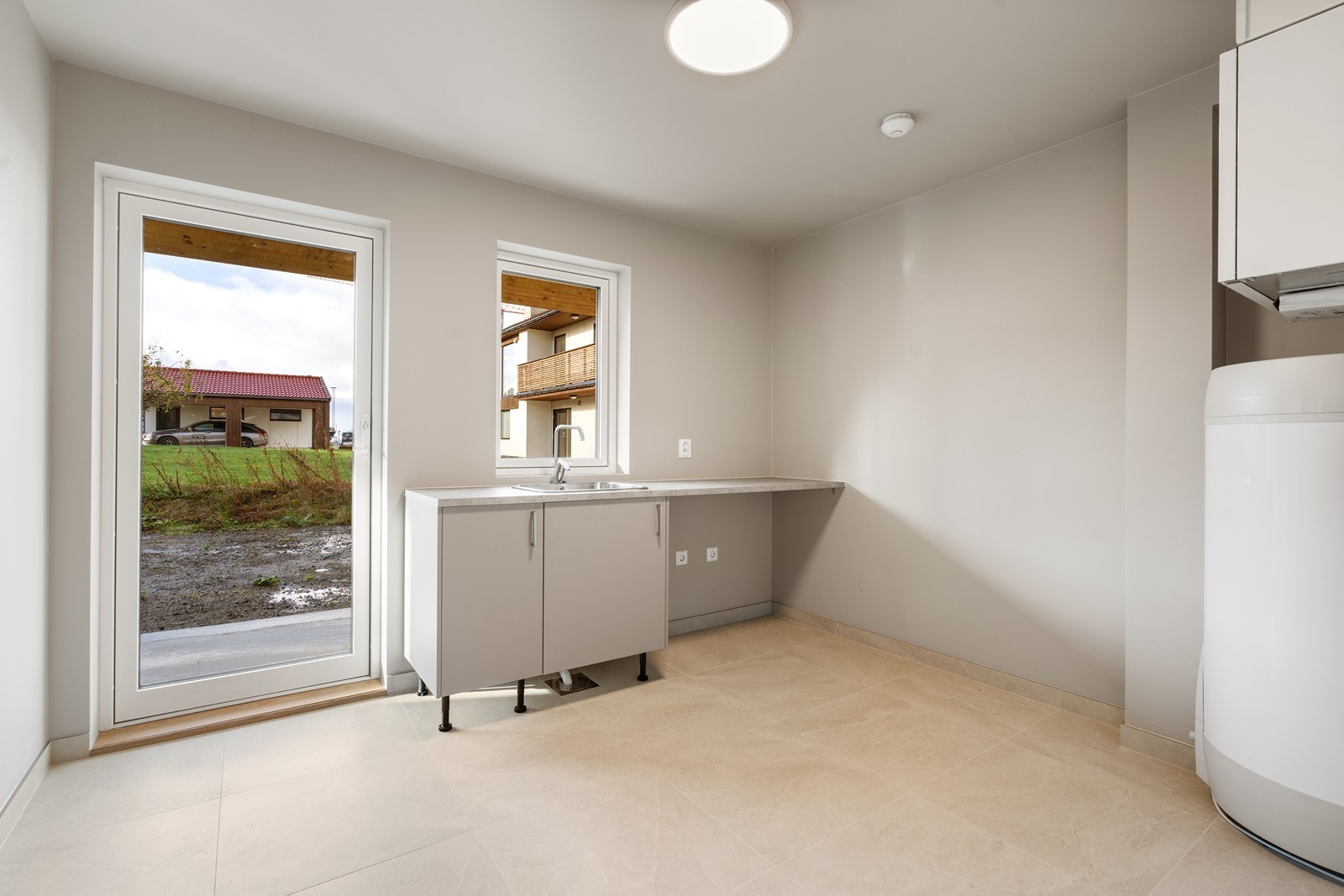 Romslig vaskerom med helfliset gulv. God plass til å tørke klær og oppbevaring Galleribilde