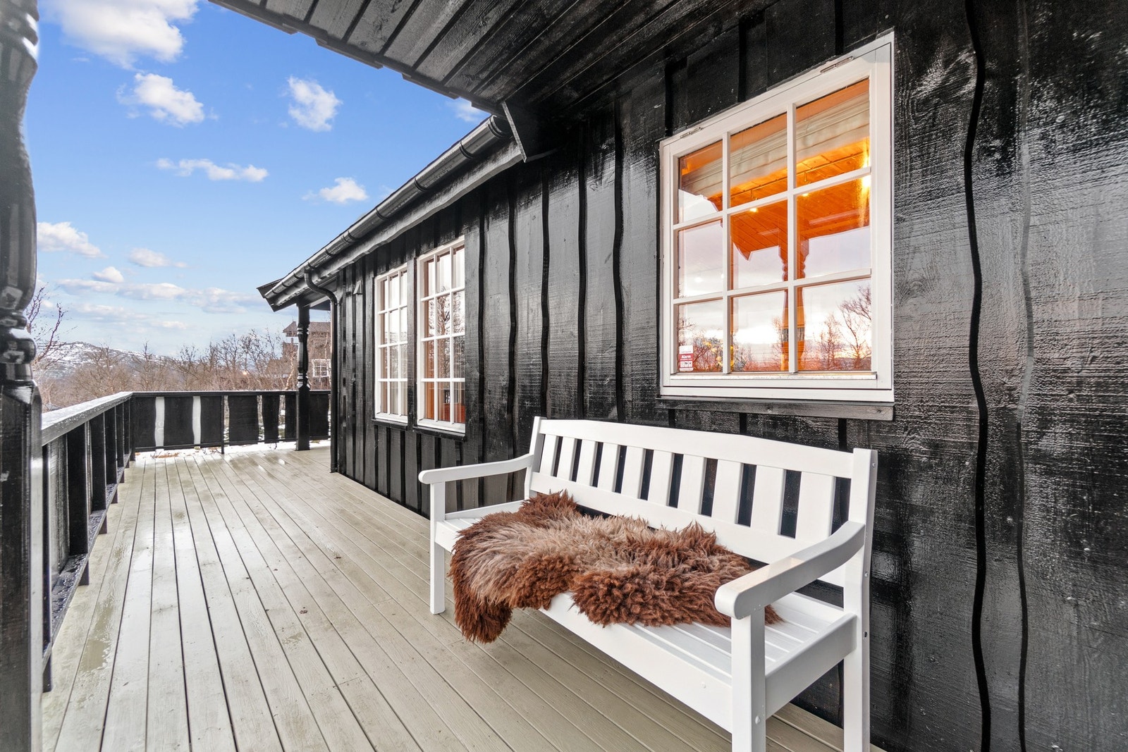 Når du kommer opp trappen til inngangspartiet har du en terrasse som strekker seg langs to sider av hytten. Galleribilde