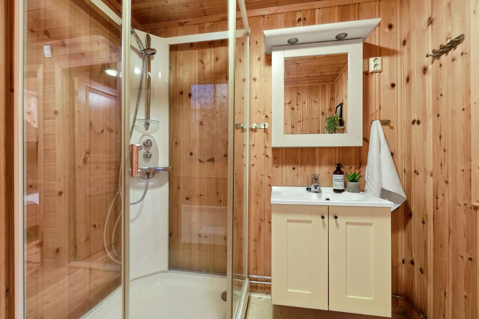 Badet er utstyrt med servant med underskap, toalett og dusjkabinett. Galleribilde