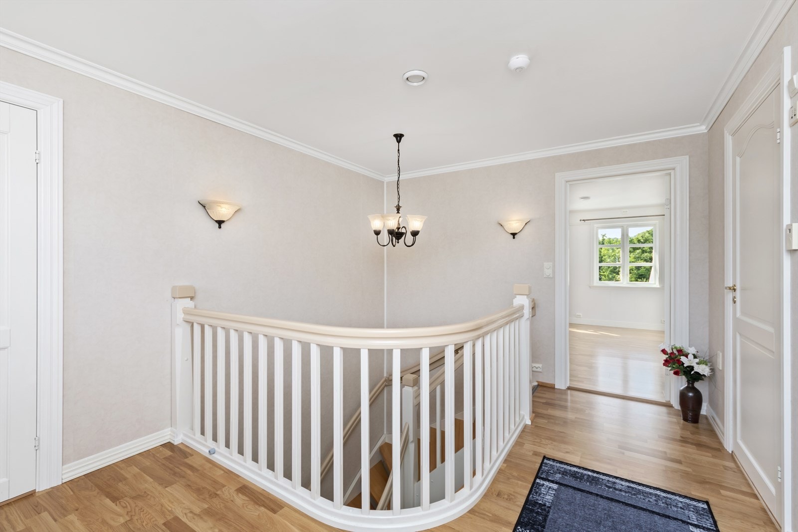 Gangen er stor og romslig med lysekrone over trappen Galleribilde
