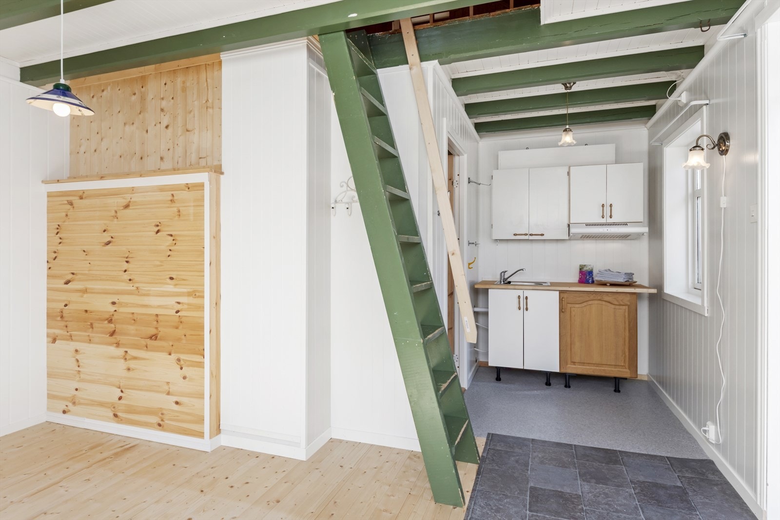 I hjørnet står det et lite hybelkjøkken Galleribilde