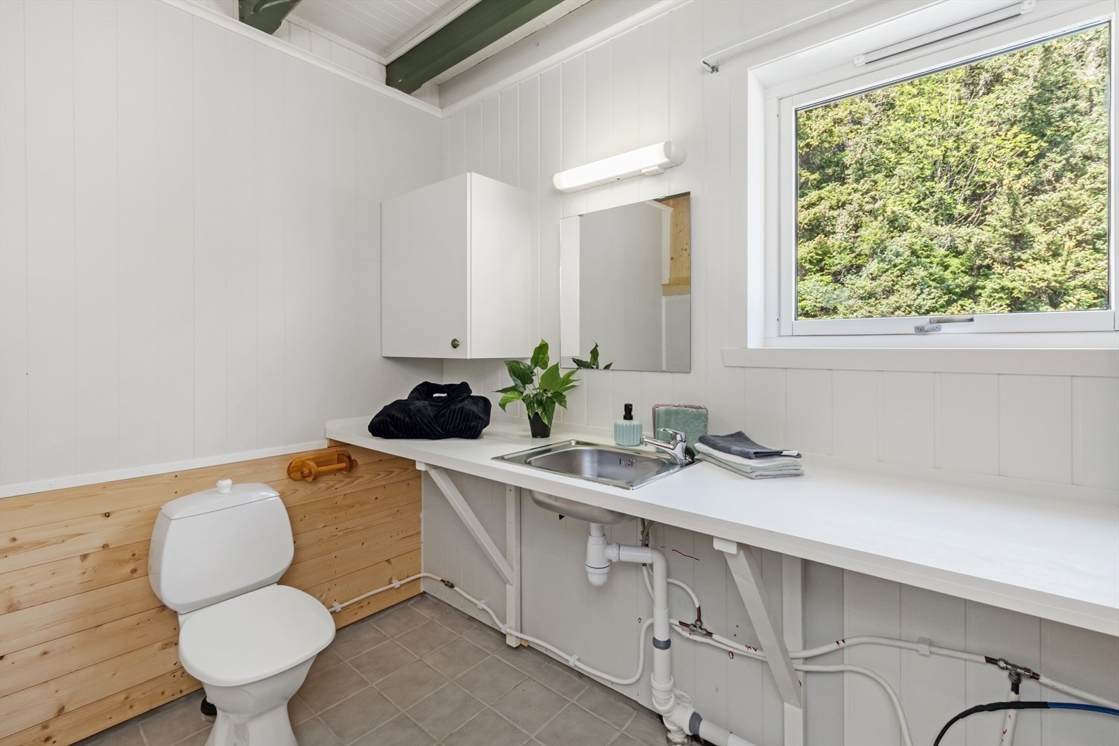 Badet i uthuset har toalett, utslagsvask og opplegg til dusj. Galleribilde