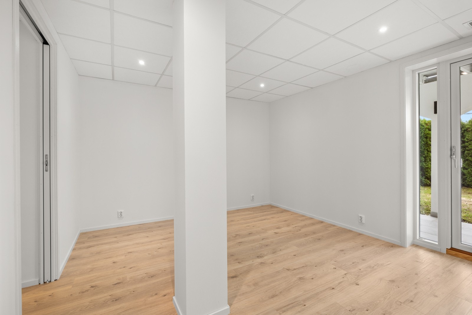 Lyst og romslig soverom med parkett på gulv, malte vegger og systemhimling med downlights. Galleribilde