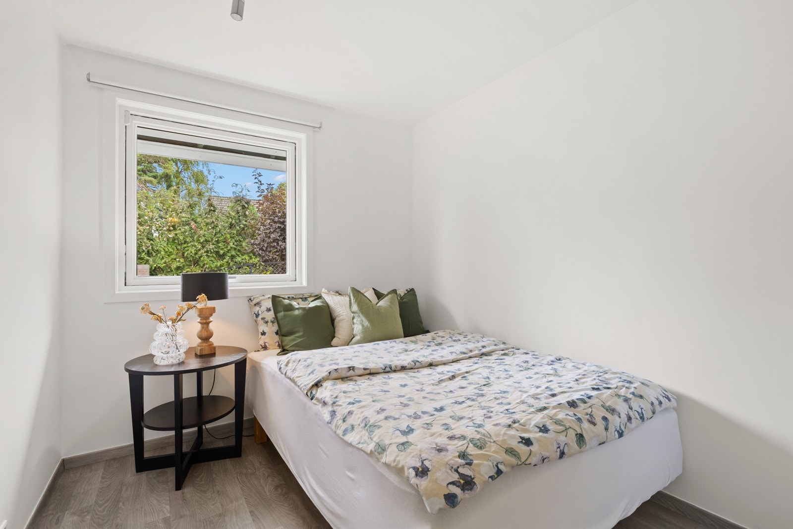 Med veggflater malt i lyse og stilrene farger og gulvflater i ny laminat fra 2023, står soverommene i stil med resten av boligen. Galleribilde