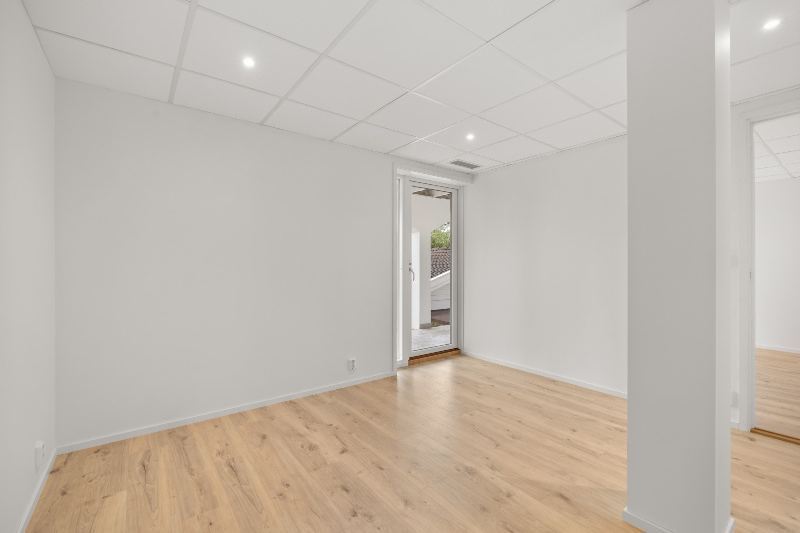 Rommet har utgang til uteplass, noe som gir en fin forbindelse til hagen og godt med dagslys. Galleribilde