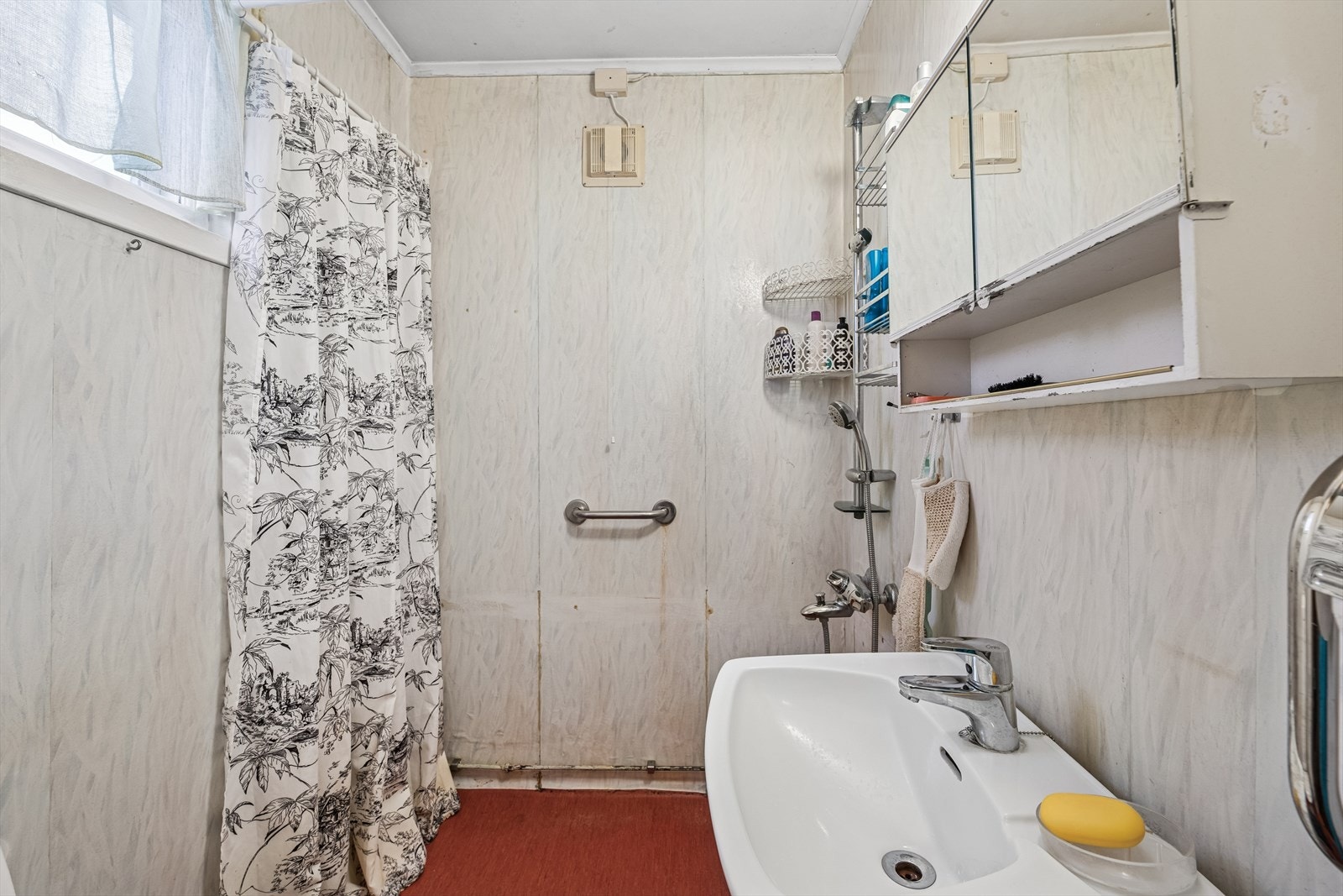 Baderommet er innredet med servant, gulvstående toalett, speilskap og dusj. Galleribilde