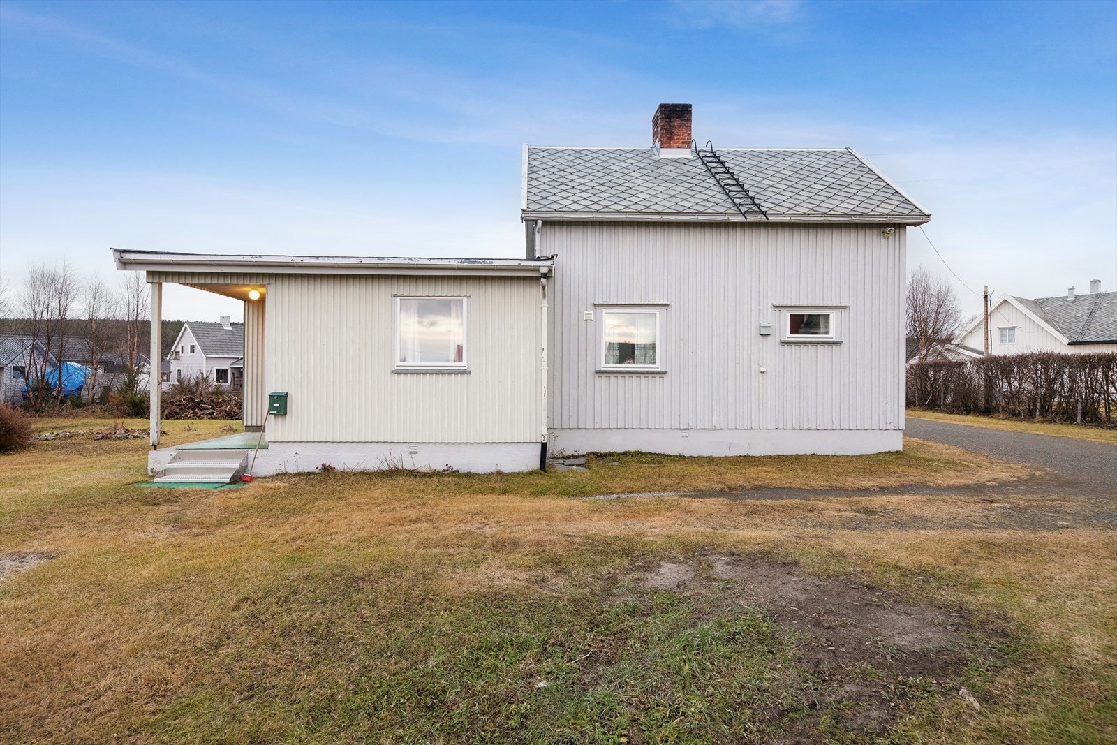 Eiendommen har en stor tomt opparbeidet med plen og grus i innkjøring, naturlig vegetasjon. Galleribilde