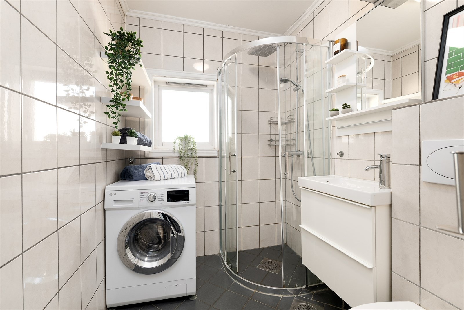 Flislagt bad med varmekabler i gulv og plass til vaskemaskin. Galleribilde