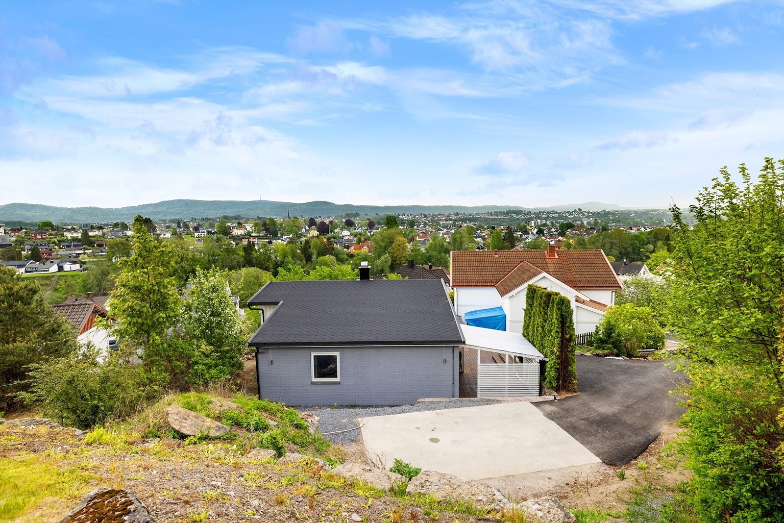 Parkering i gårdsplass. Det er montert Teslalader på husvegg Galleribilde