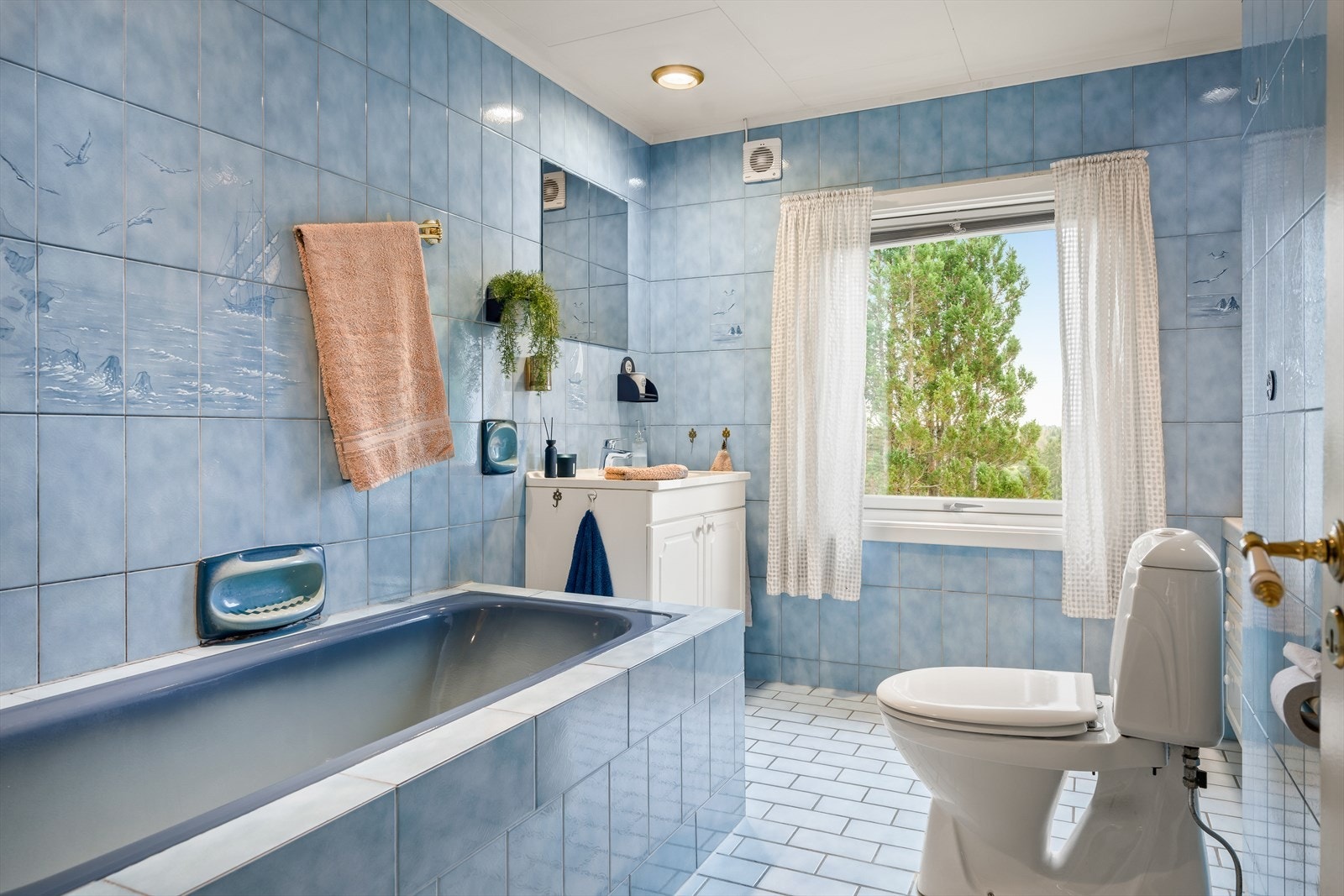 Badet består av servant med innredning, badekar og gulvklosett. Galleribilde