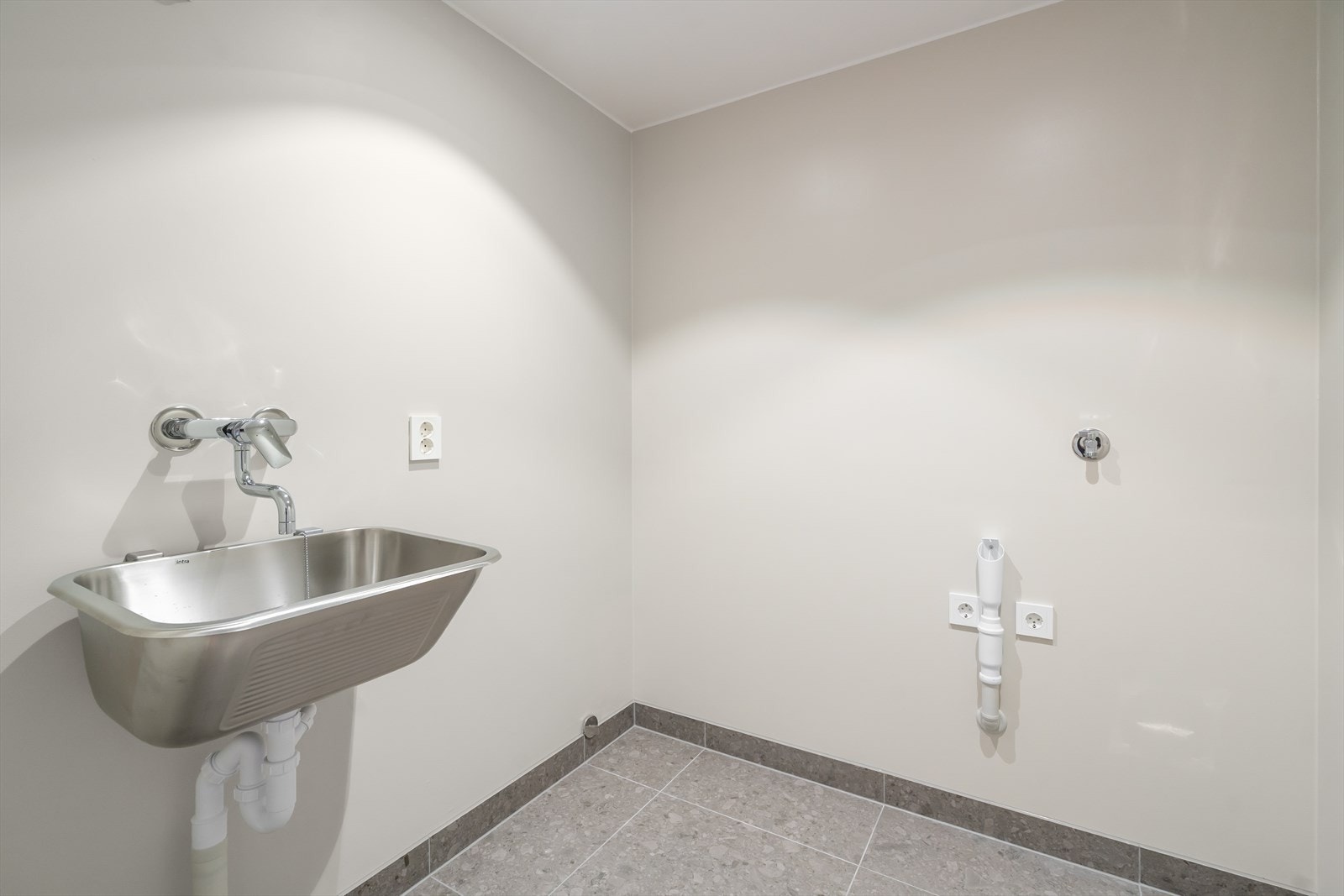 Separat vaskerom hvor man både plasserer vaskemaskin og tørketrommel - i tillegg til at man får litt ekstra lagringsplass. Utslagsvask i stål. Galleribilde