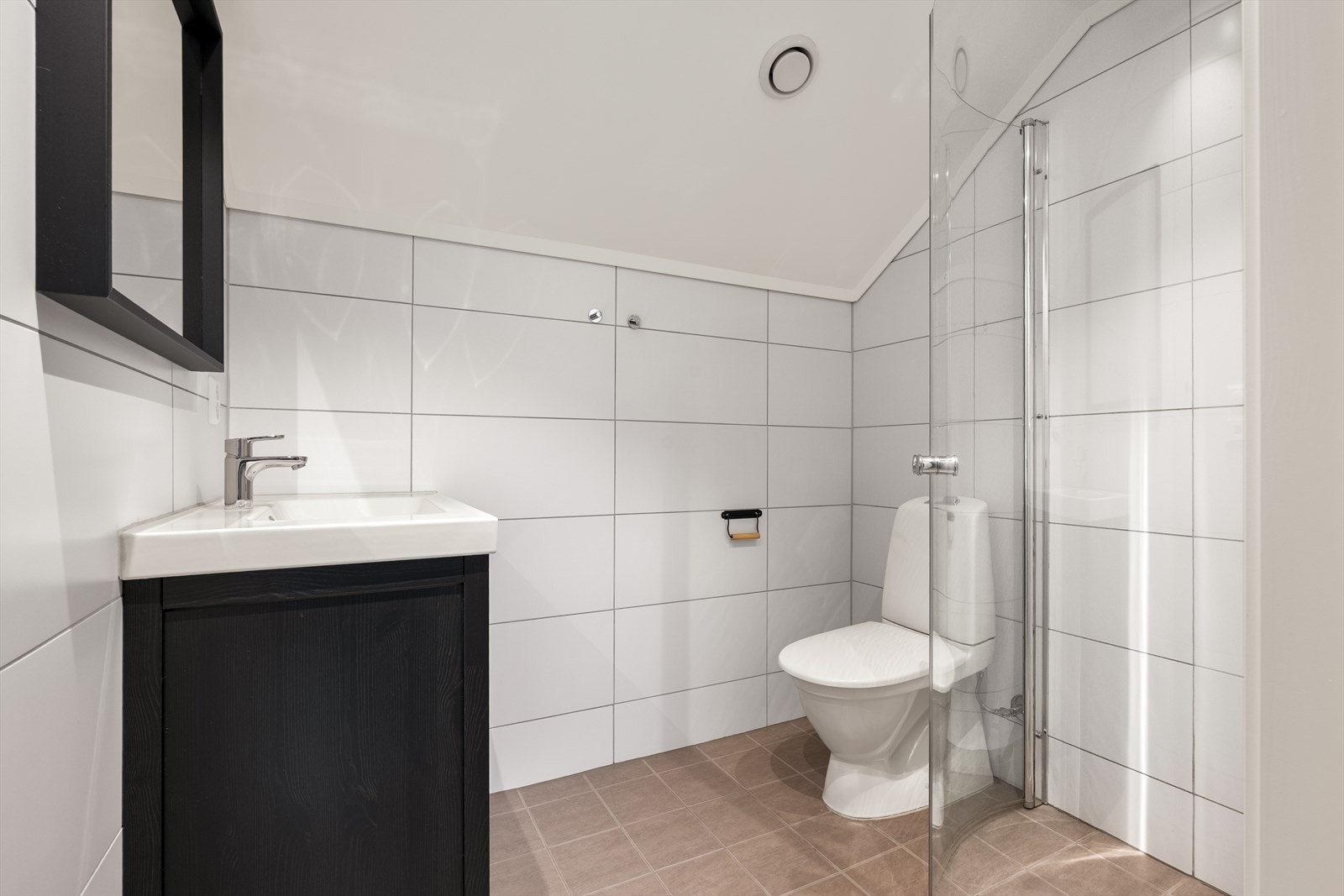 Pent, moderne bad i loftsetasjen. Badet er innredet med servant, dusj med glassdører og toalett. Galleribilde