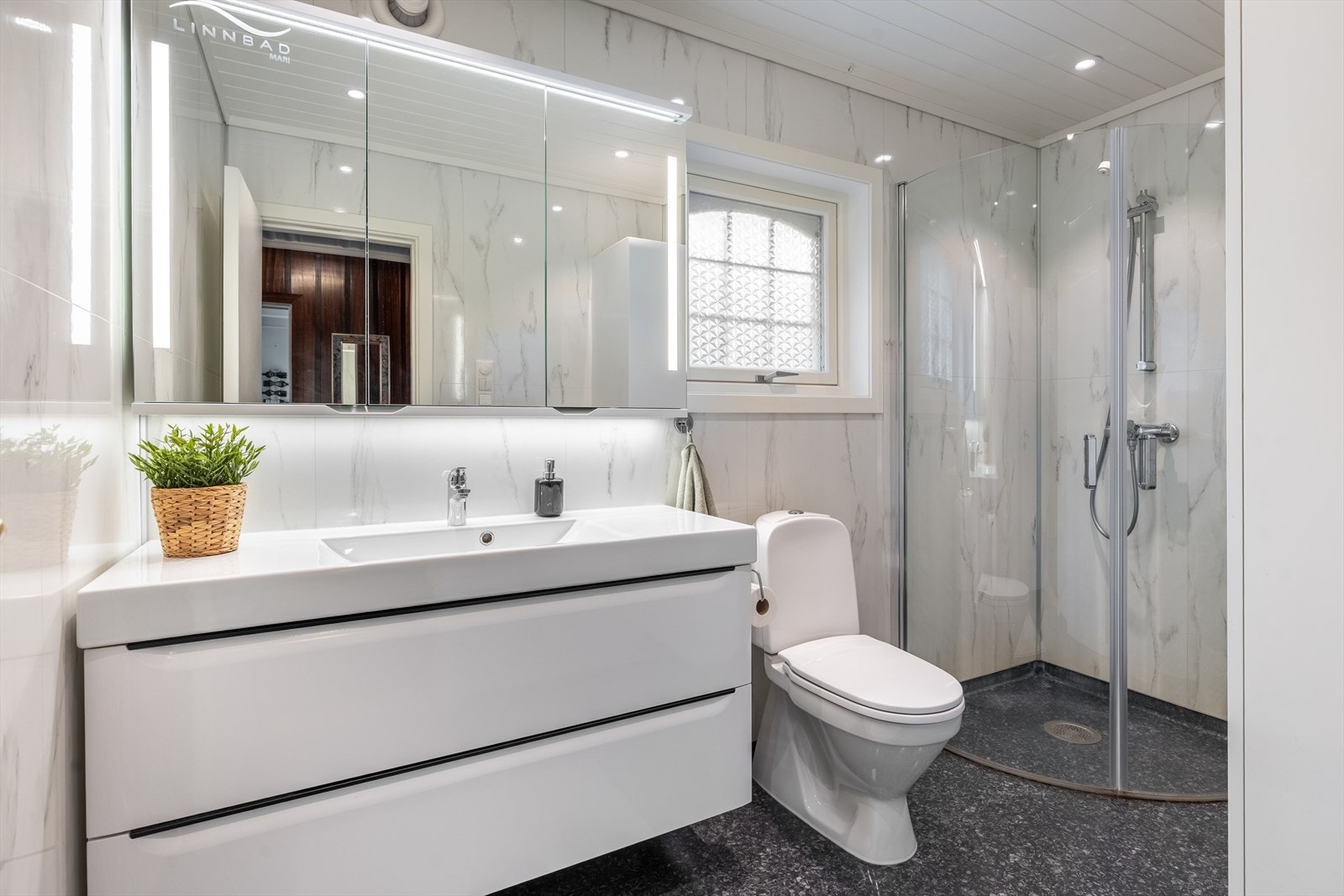 Stilrent bad med moderne innredning, downlights og flotte overflater Galleribilde