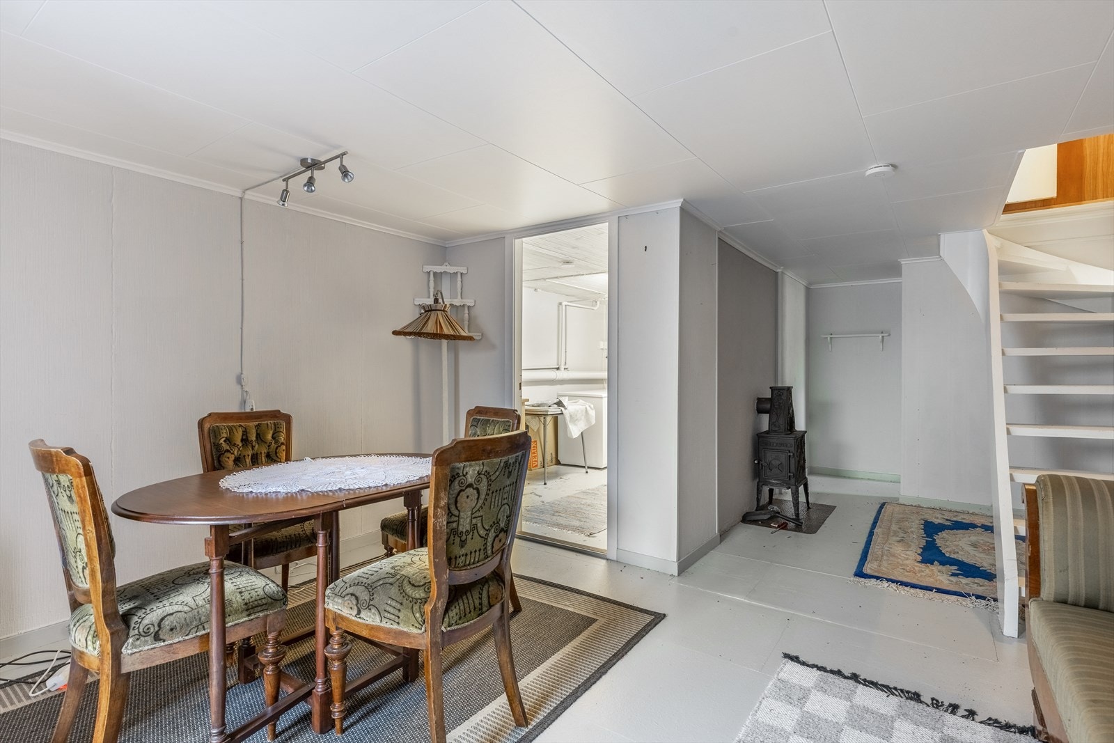 Romslig underetasje med vedovn og trapp opp til hovedetasjen Galleribilde