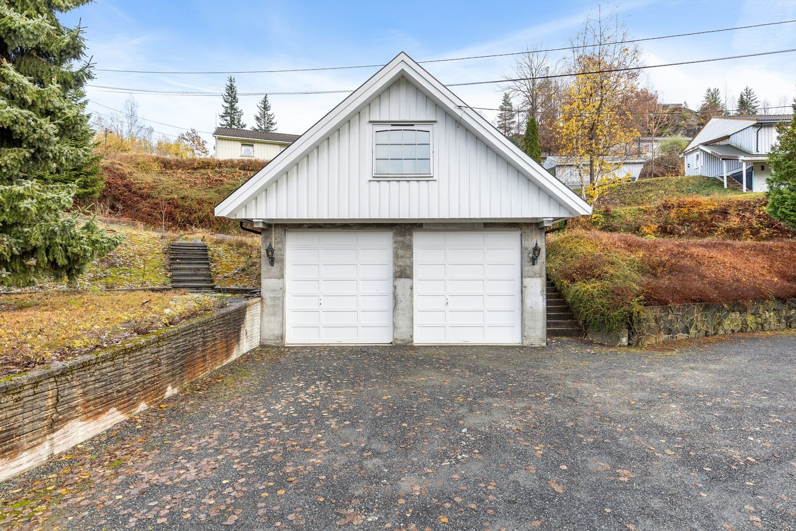 Garasjen har ekstra høy port, med plass til både bobil og traktor. I tillegg er det tilrettelagt med oppstillingsplass ved siden av garasjen Galleribilde