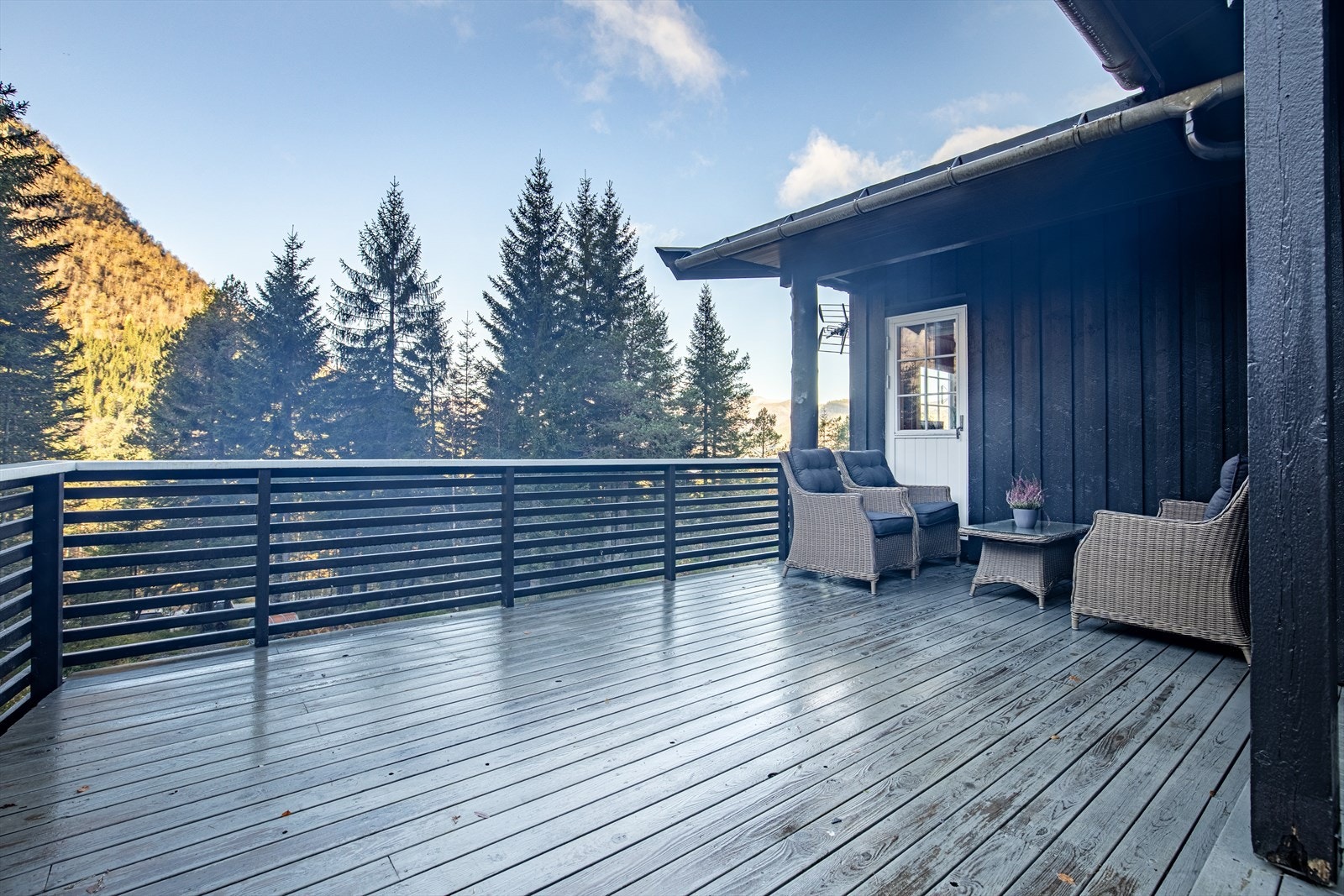 Romslig altan med plass for sittegrupper og grill Galleribilde