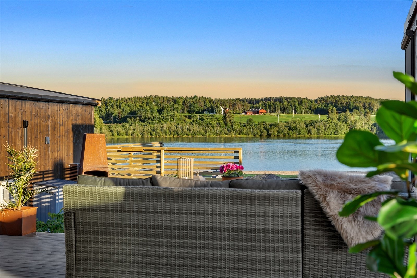 Hytta har et moderne uttrykk med store glassflater og rene linjer. Legg merke til at du har mulighet å åpne dørene sånn at terrassen blir en del av stuen. Galleribilde