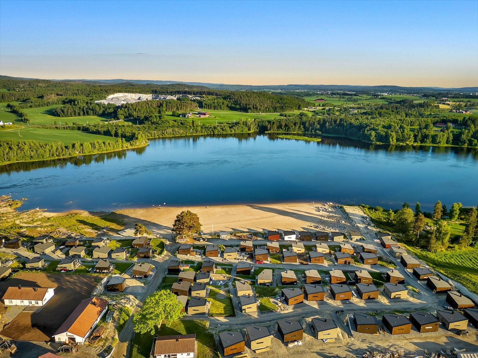 Hyttene er oppført i 2021 og byr på strandlinje like utenfor hyttedøra. Galleribilde