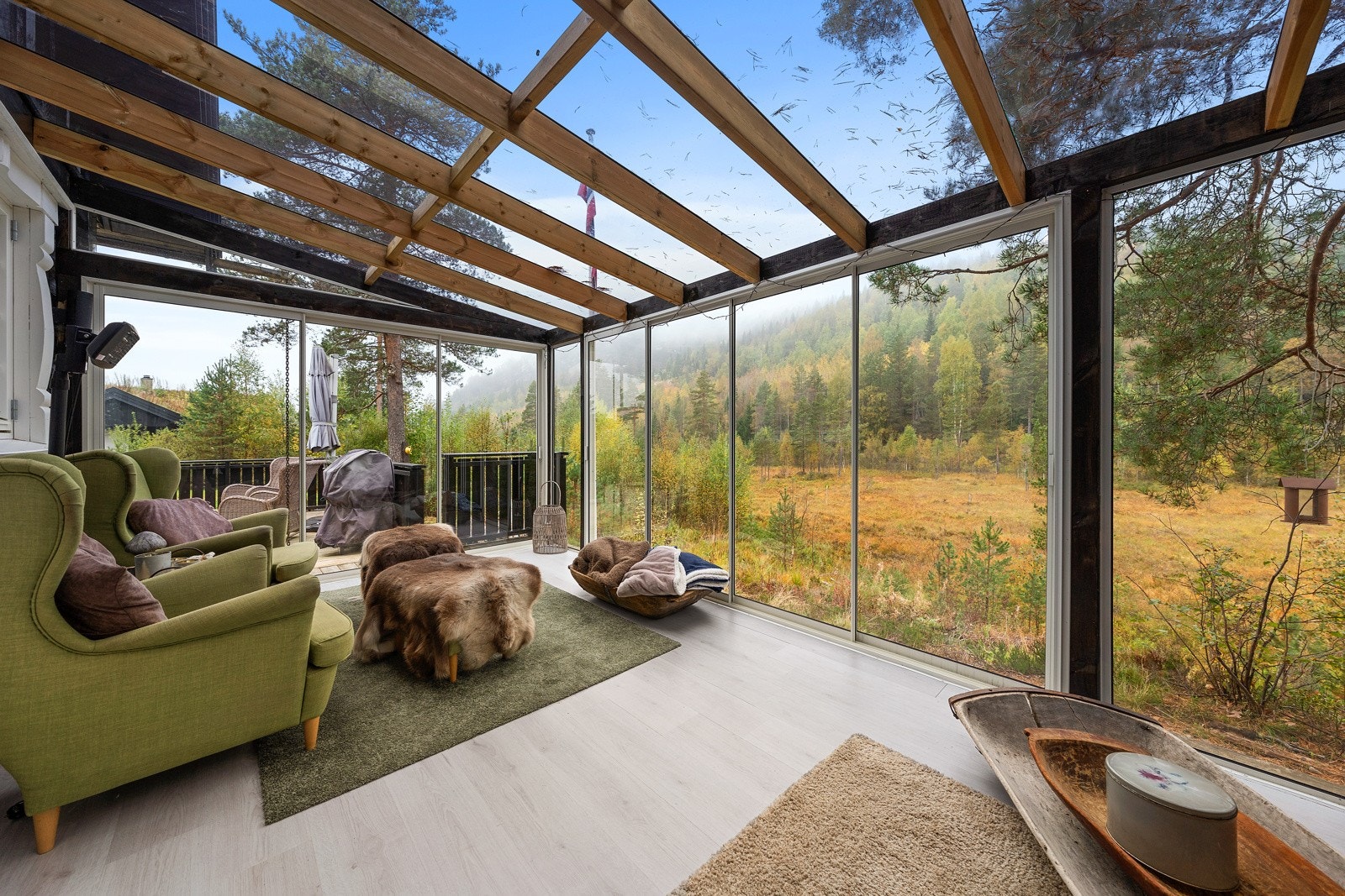 Koselig innglasset veranda med vakker utsikt til skogen og terrenget rundt hytta. Galleribilde