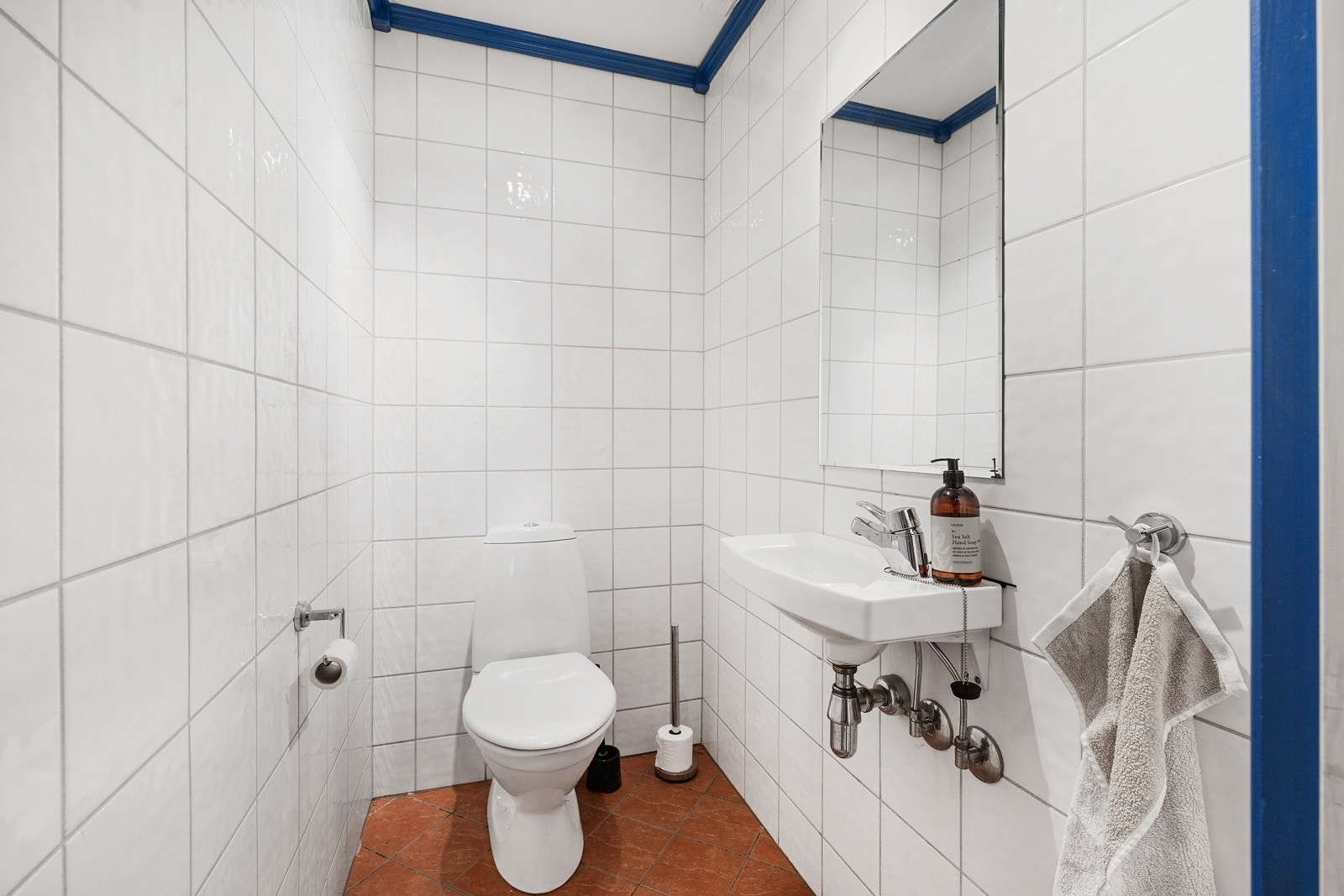 Separat toalettrom med fliser på vegger og gulv. Innredet med toalett og vask. Galleribilde