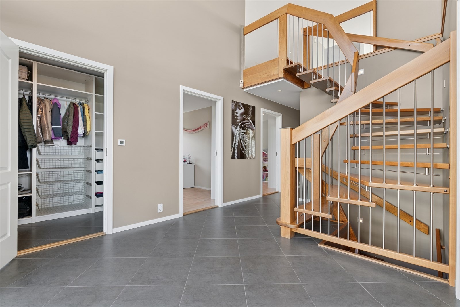 Fra hallen har man tilkomst til et garderoberom hvor man har god plass til å henge fra seg yttertøy og sko. Galleribilde