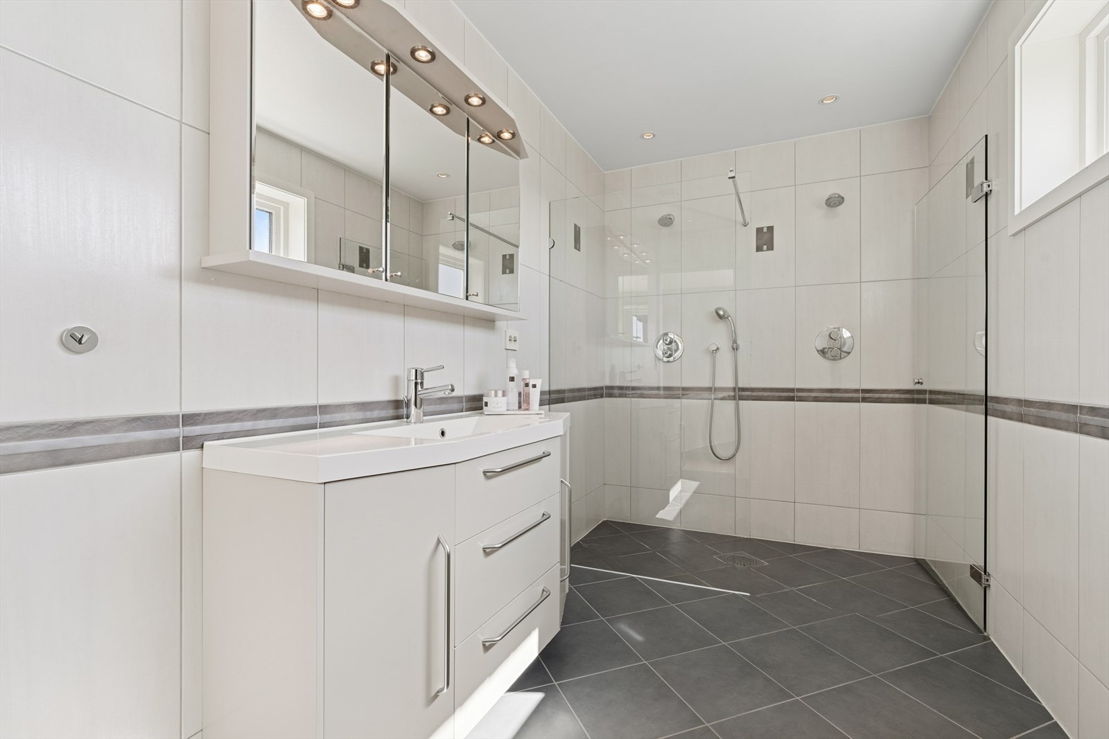 Baderommet tilhørende hovedsoverommet har dobbel dusj, vegghengt toalett og veggseksjon med servant. Galleribilde