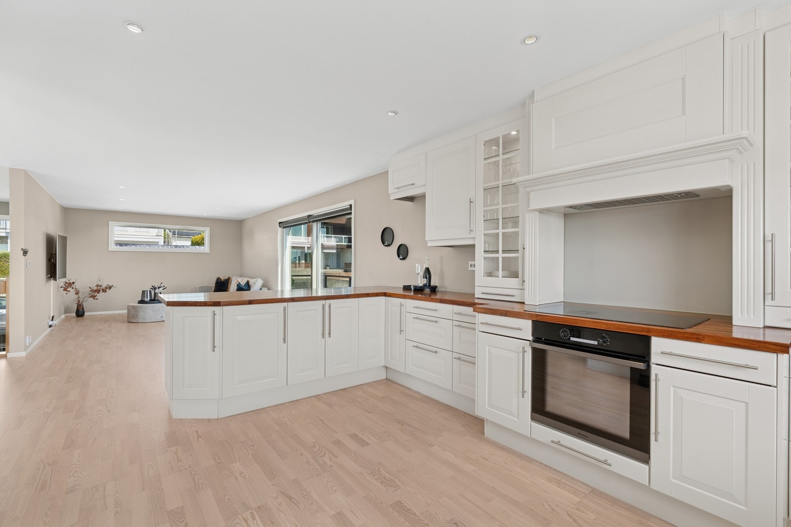 Kjøkkenet er tidløst innredet med hvite, profilerte fronter og benkeplate i tre. Galleribilde