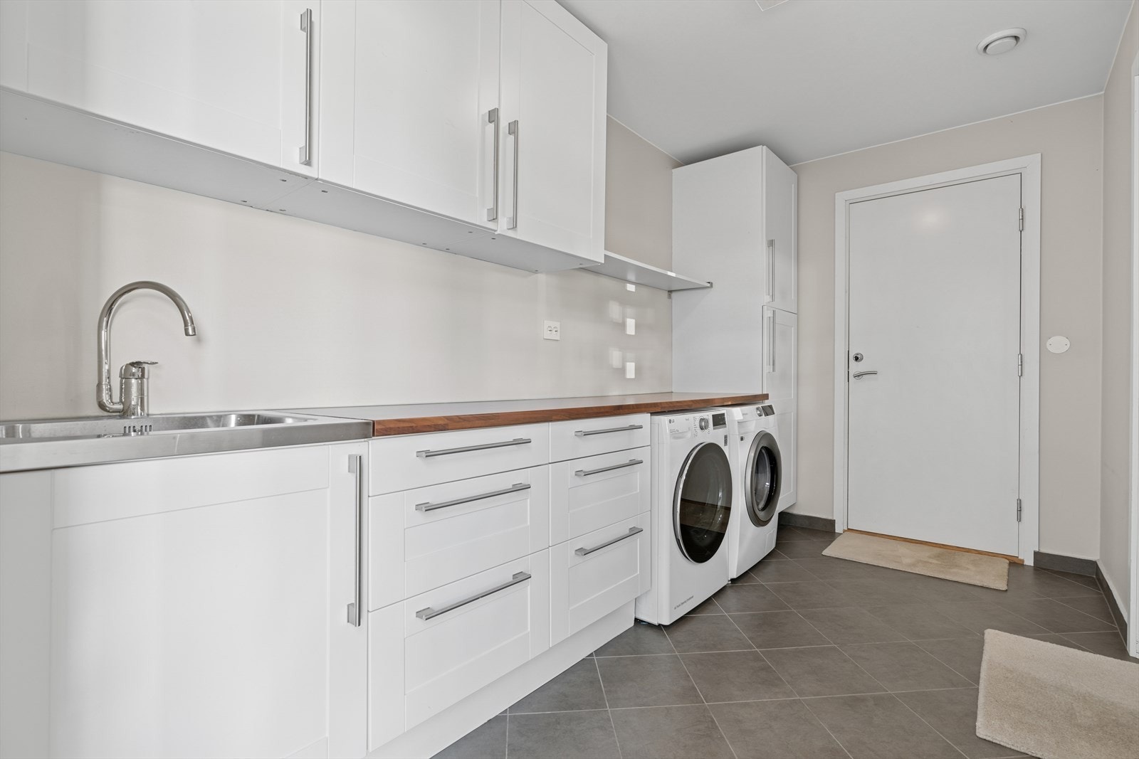 I tilknytning til hallen finner man et praktisk vaskerom kombinert med bi-inngang fra både gårdsrom og garasje. Galleribilde