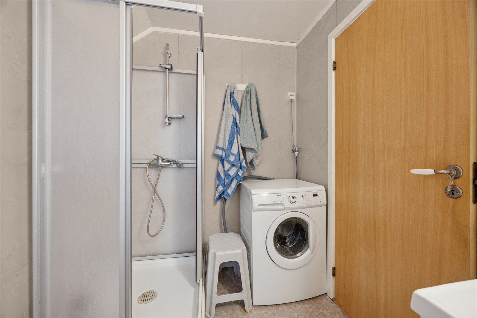 Baderommet er innredet med dusjkabinett og opplegg til vaskemaskin. Galleribilde