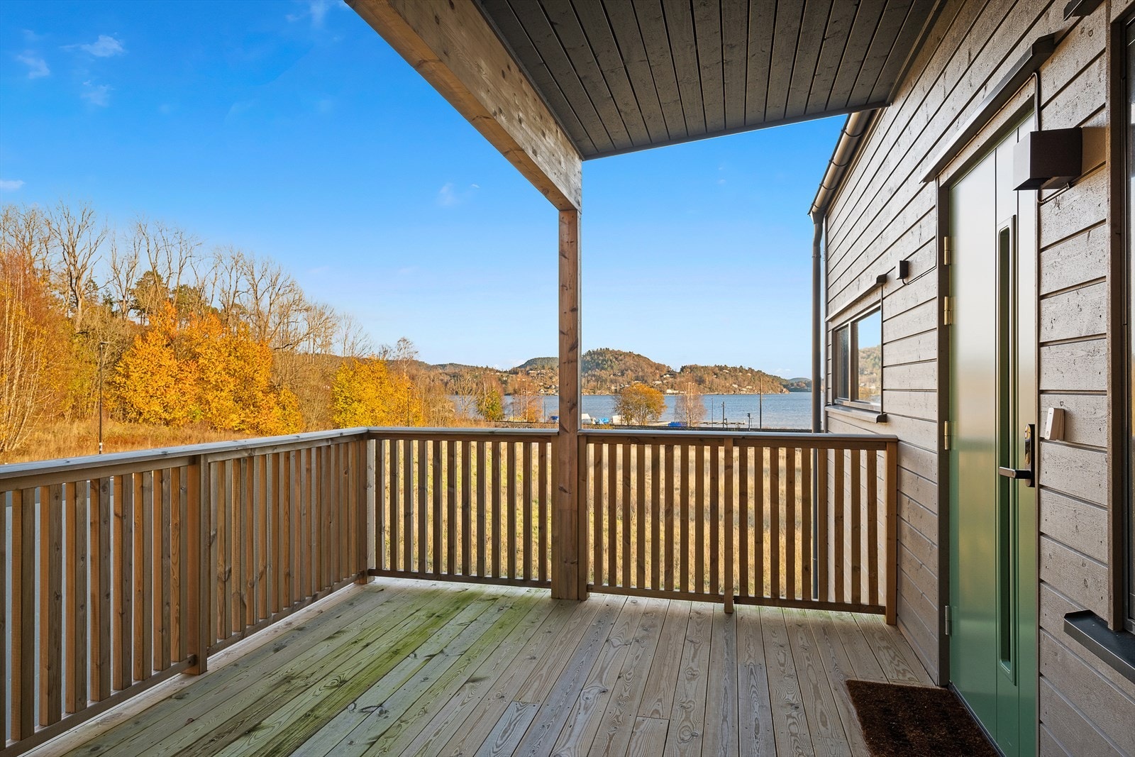 Overbygget inngangsparti med plass til sittemøblement og utsikt til sjøen Galleribilde