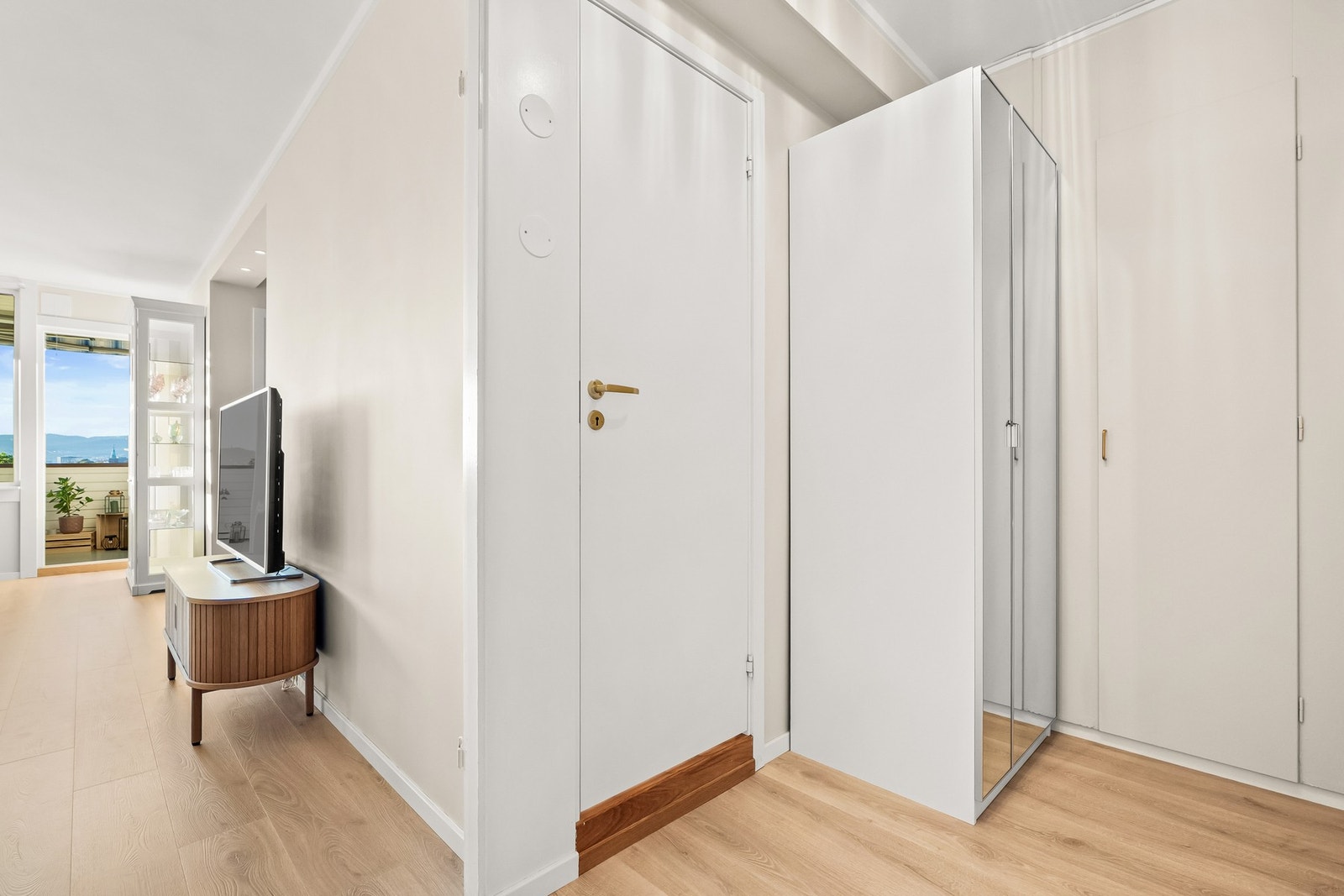 Pent stilvalg med glatte, beigmalte veggflater og nyere lyst laminatgulv Galleribilde