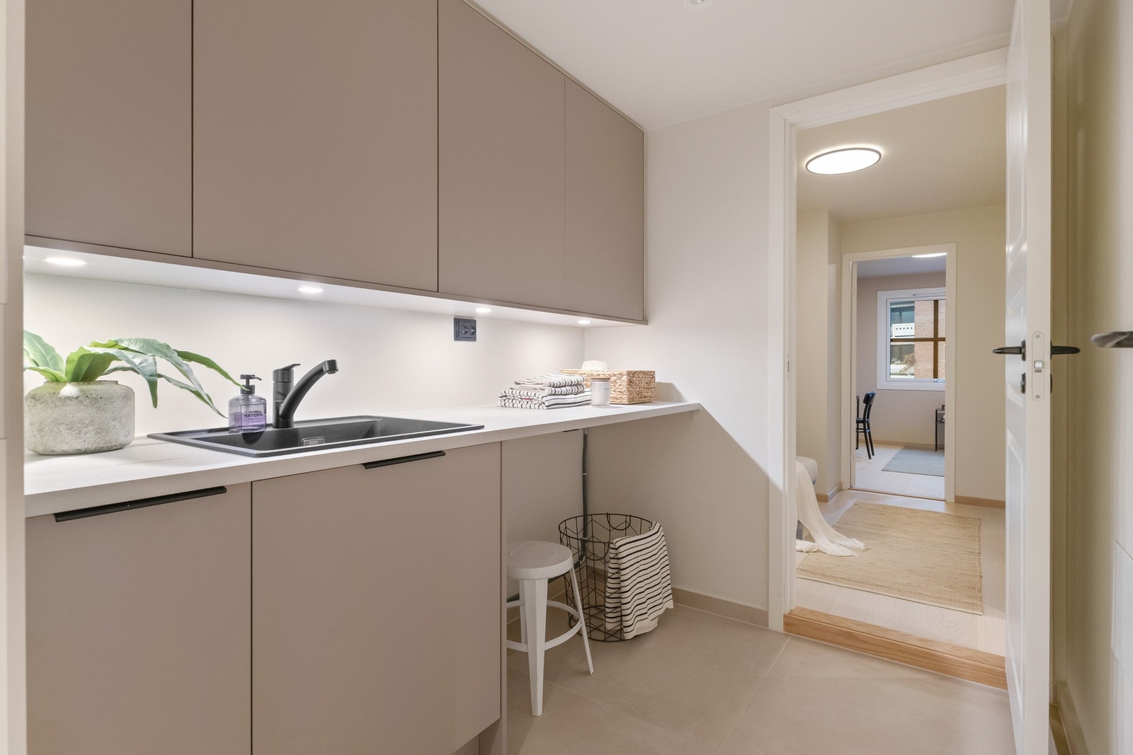 Vaskerommet med store 80*80 fliser på gulv gir deg et eget rom for både klesvasken og ekstra oppbevaringsplass i tilhørende innredning som er satt inn Galleribilde