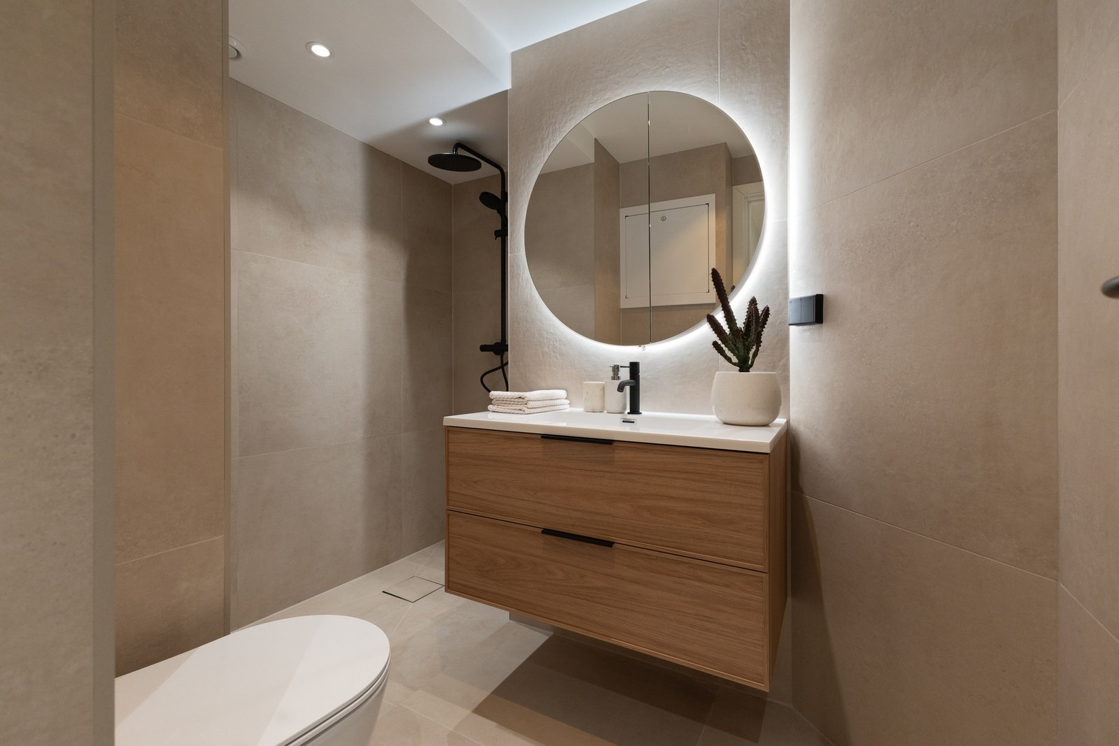 Bad II: Meget lekkert flislagt bad med moderne, store 80*80 fliser i beige utførelse. Badet er bygget opp på nytt i 2025 med ny membran, nytt sluk og nye varmekabler. Galleribilde