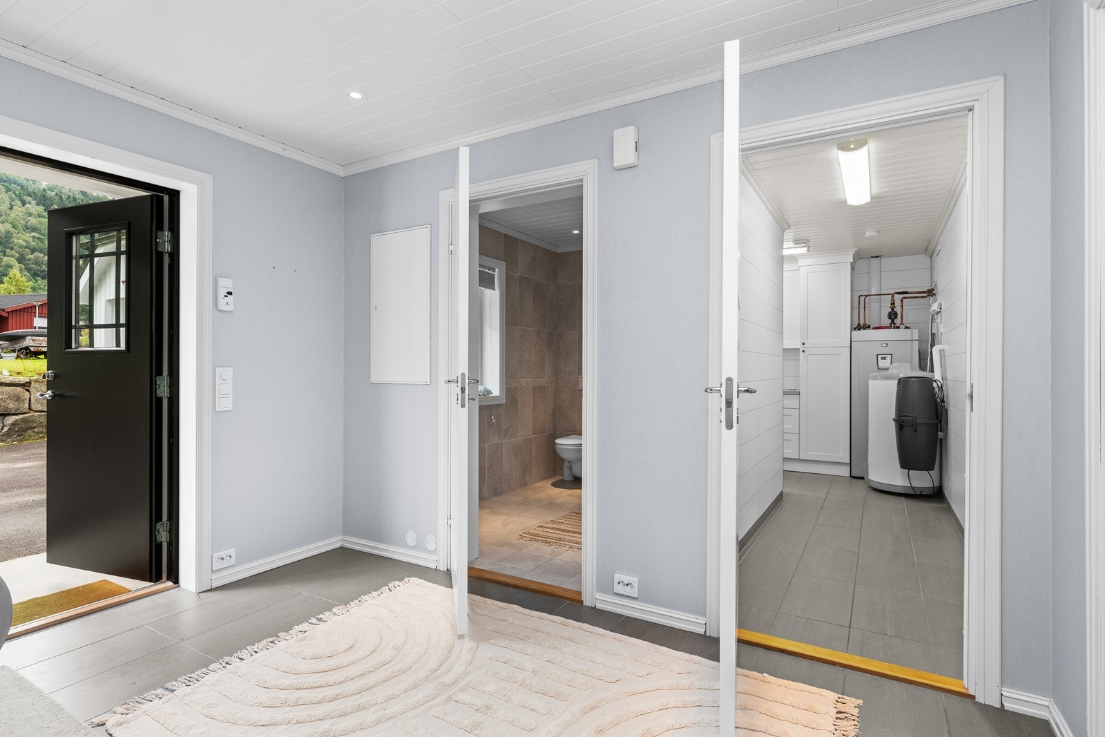 Boligen har overbygd inngangsparti med utvendig downlights i tak og doble inngangsdører. Fra gang er adkomst til bad og vaskerom Galleribilde