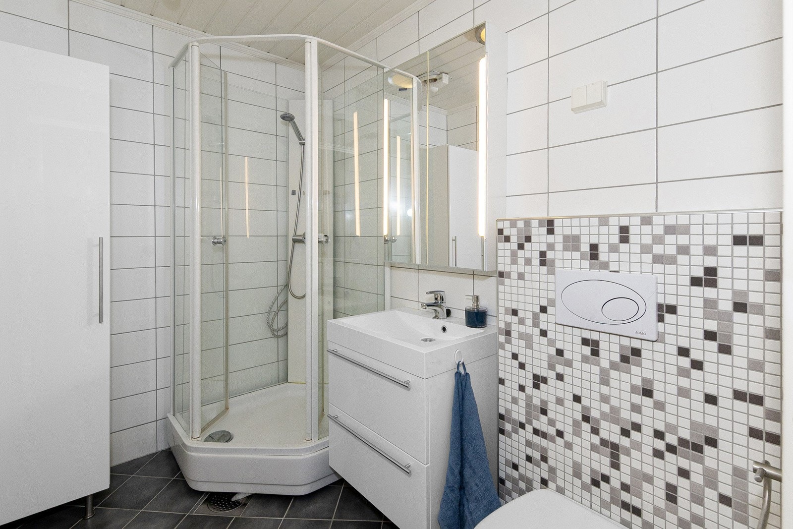 Badet har dusjkabinett, servant i innredning, høyskap, speilskap m/innfelt lys samt vegghengt toalett Galleribilde