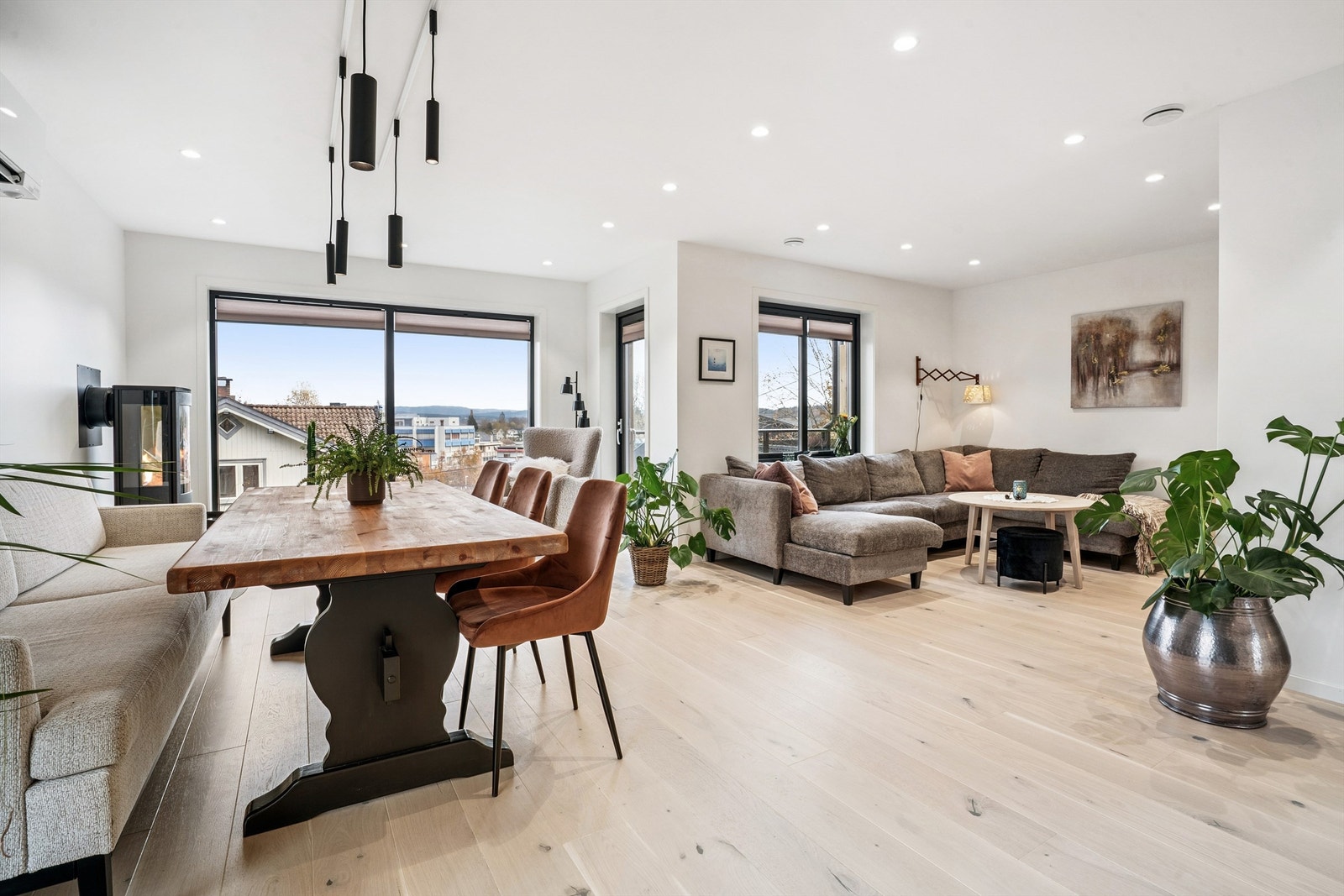 Vi kommer opp til boligens sosiale sone med åpen løsning mellom stue og kjøkken. Galleribilde