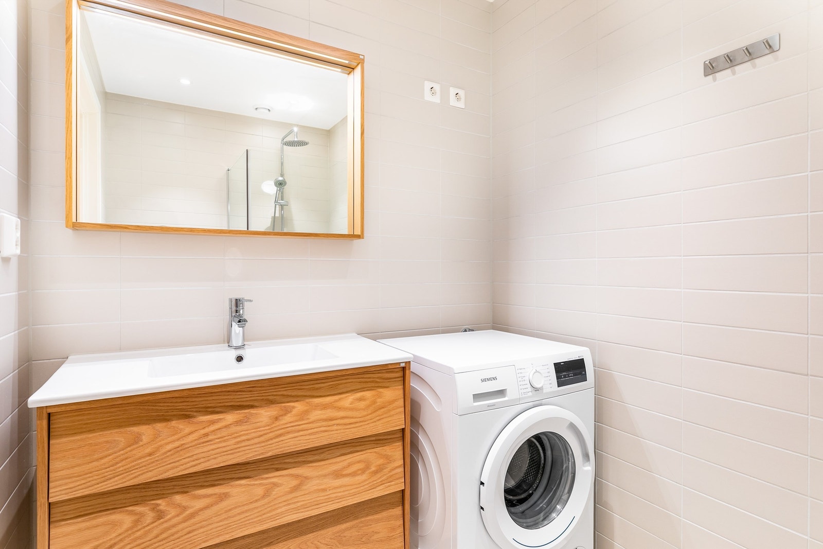 Badet er stilfullt med fliser i varme nyanser og lekre Hafa baderomsmøbler. Galleribilde