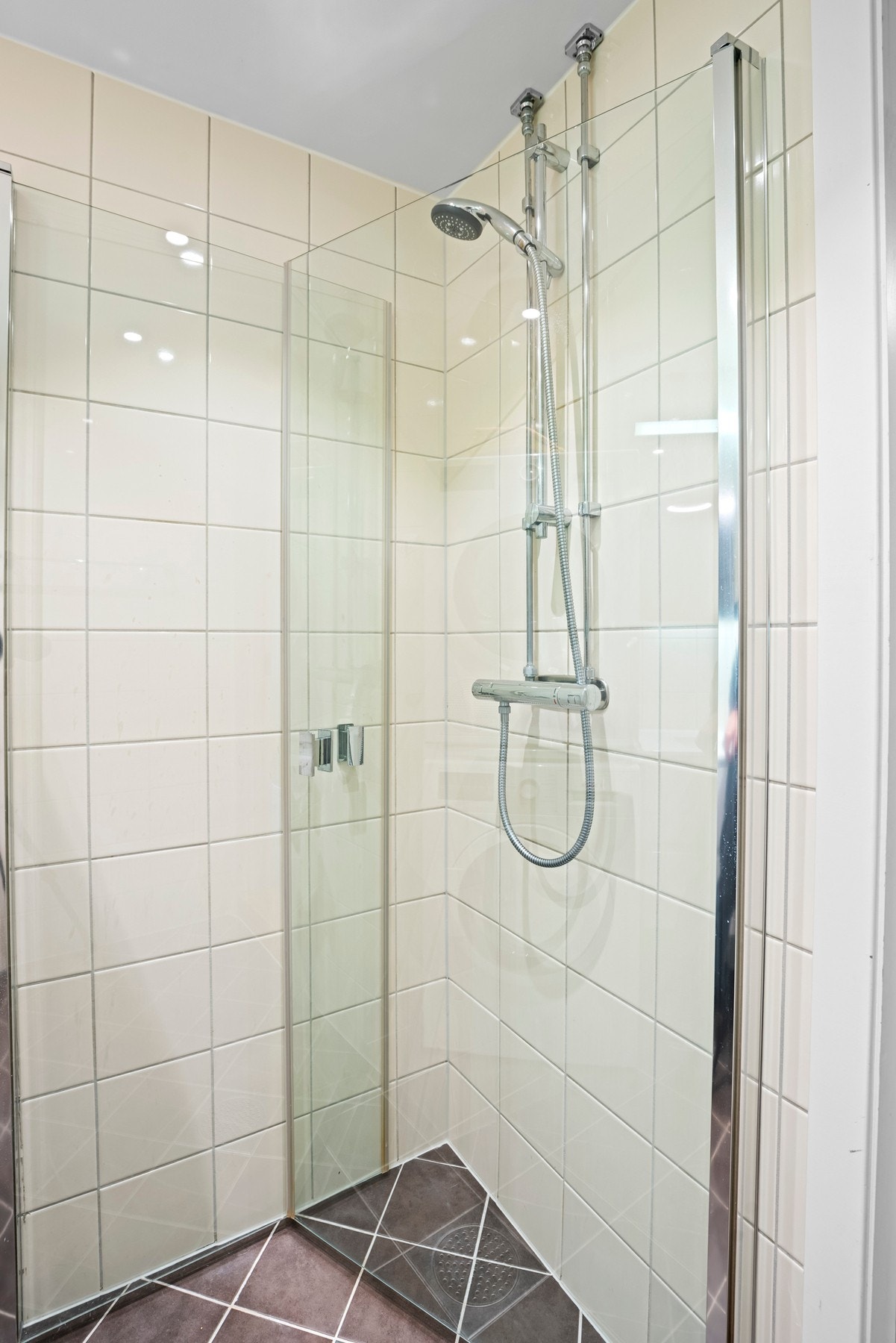 Badet har opplegg for både vaskemaskin og tørketrommel, samt et dusjhjørne med innfellbare dusjdører i glass. Galleribilde