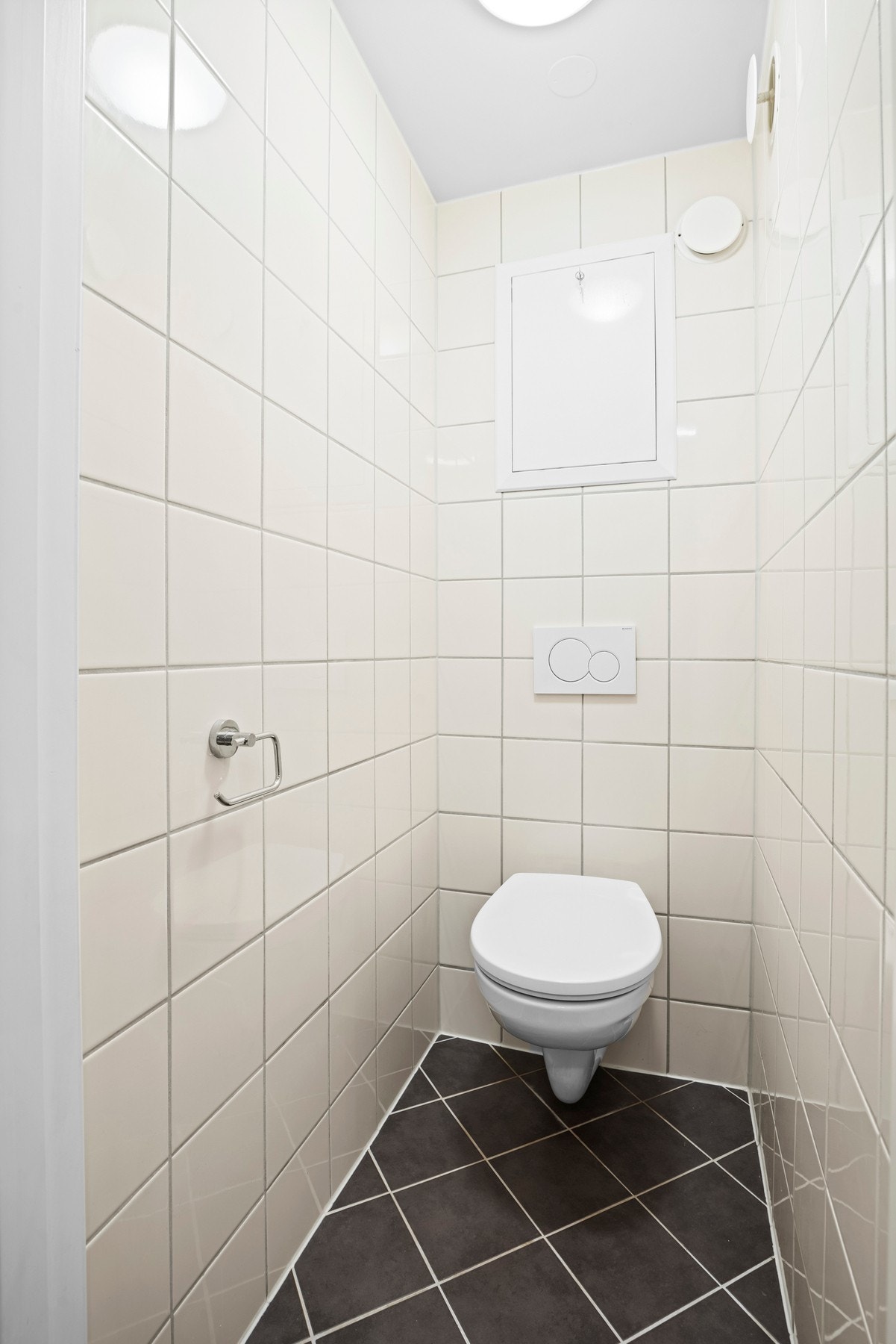 Vegg i vegg med badet ligger et eget, praktisk wc-rom innredet med vegghengt toalett. Rommet har flislagte overflater i samme utførelse som badet. Galleribilde