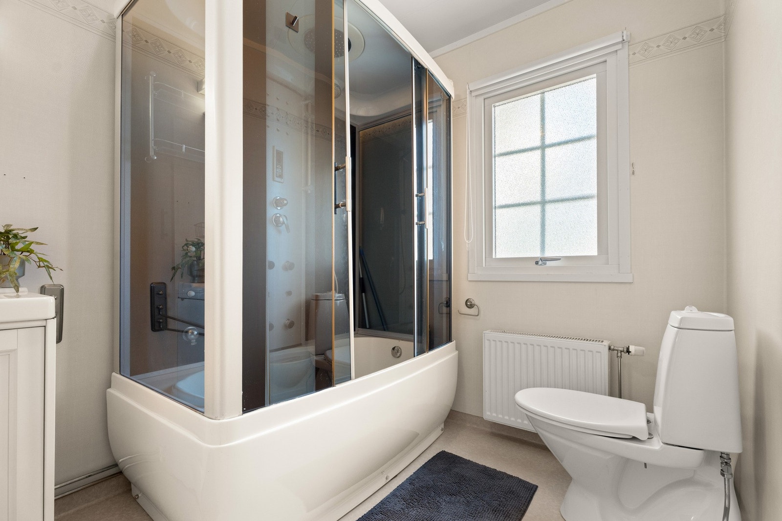 Innredning med benkeskap, servant, speil, skap, dusjkabinett og gulvstående toalett Galleribilde