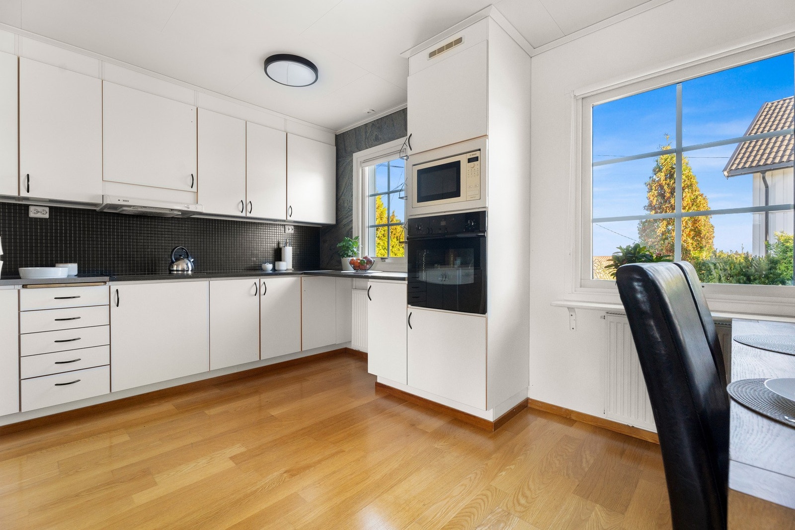 Kjøkkenet har innredning med slette fronter og laminat benkeplate Galleribilde