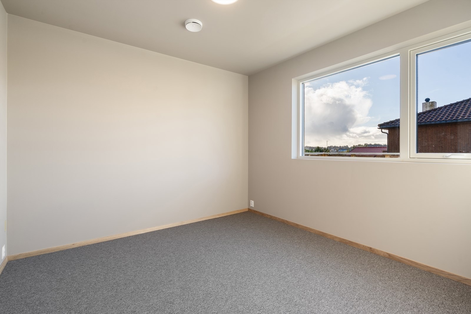 Romslig soverom i hovedetasjen med god plass til dobbelseng og tilhørende nattbord Galleribilde